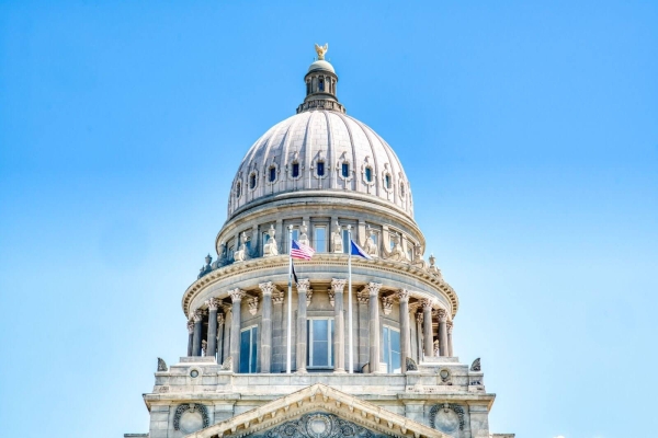 dome of the idaho state capitol with two flags waving in front