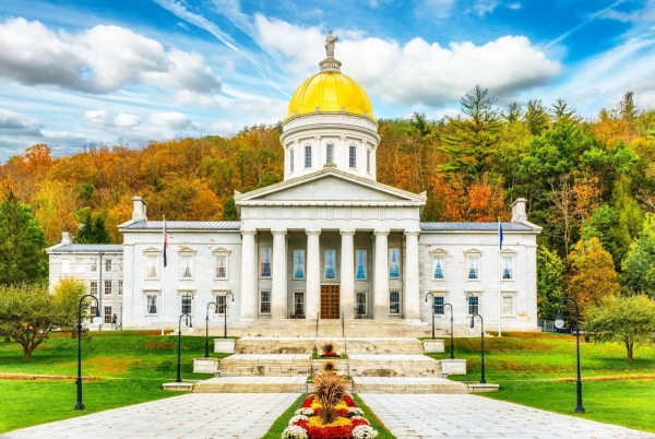 Frontal view of Vermont State House, in Montpelier, VT, with fall foliage colors, under the title 'Is Kratom Legal in Vermont?'