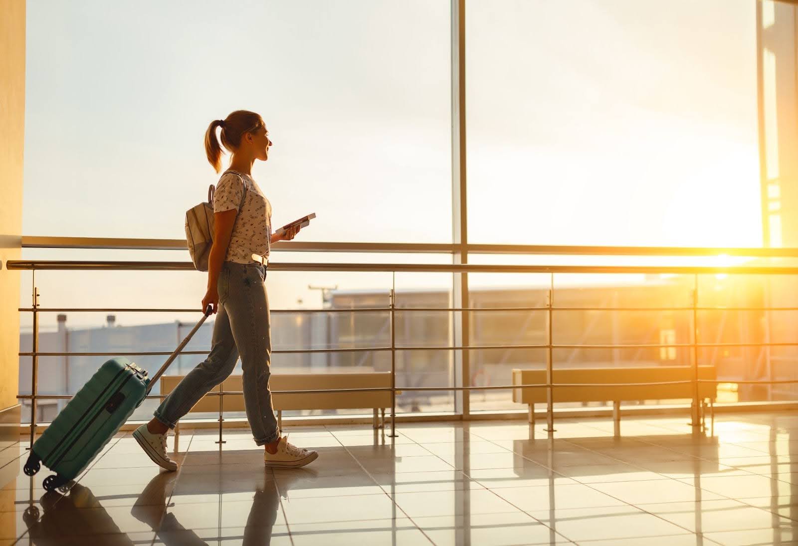 young woman with a suitcase walking through the airport