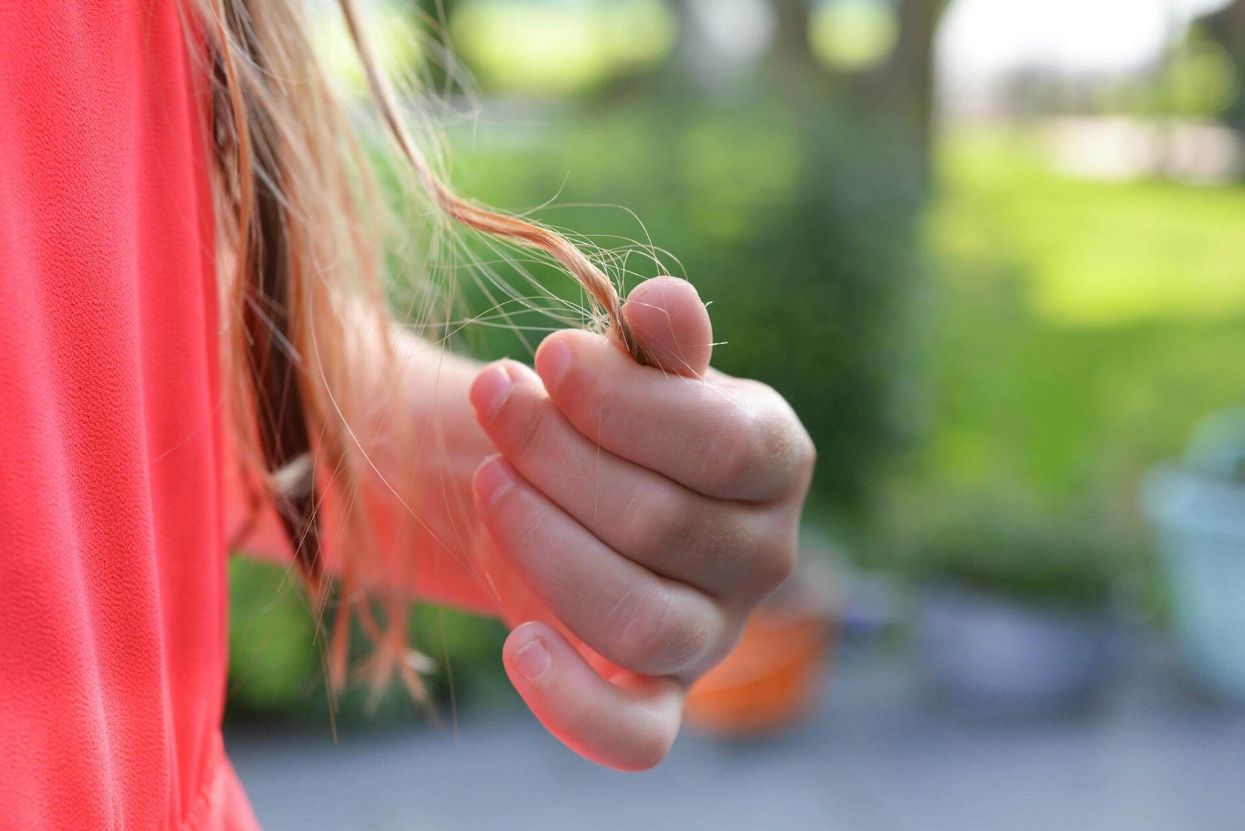 A woman’s hand holding a lock of hair